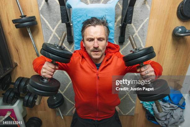 mature man pushing some weights at home - weight bench stock pictures, royalty-free photos & images