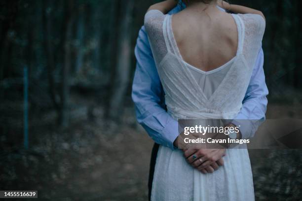 husband and wife embrace in the muir woods of california at dusk - boho wedding dresses stock pictures, royalty-free photos & images