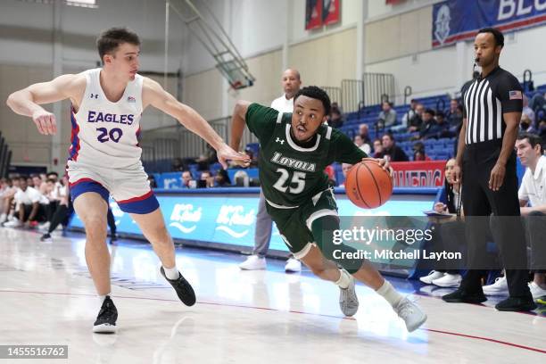 Kenneth Jones of the Loyola Greyhounds dribbles the ball by Lorenzo Donadio of the American University Eagles during a college basketball game at...