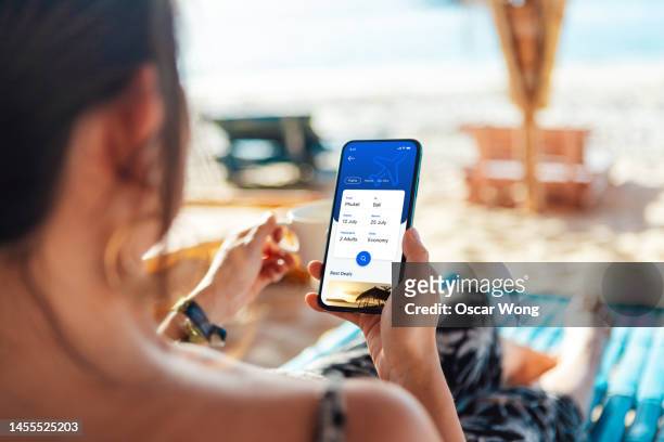 young woman booking flight tickets online with smartphone - daily life in philippines stock-fotos und bilder