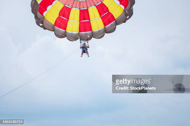 father and son parasailing during summer day at sea - parascending stock pictures, royalty-free photos & images
