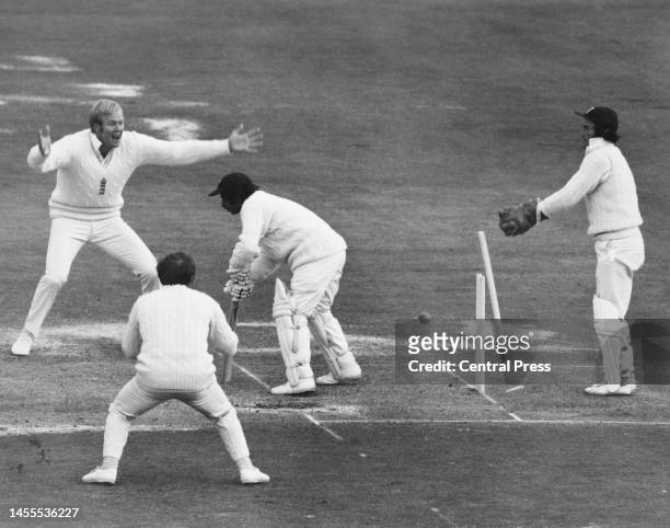 England Wicketkeeper Alan Knott and team captain Tony Greig raise their arms in celebration as Indian batsman Gundappa Viswanath is bowled out for 40...