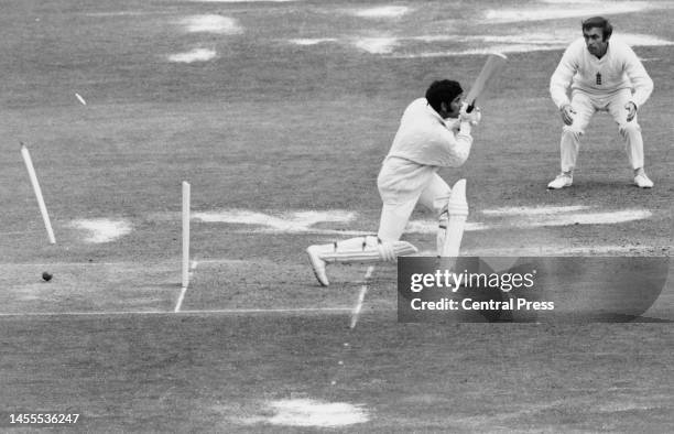 England fielder John Edrich looks on as Indian wicketkeeper batsman Farokh Engineer is bowled out for 0 runs off the bowling of Bob Willis during the...