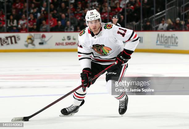 Taylor Raddysh of the Chicago Blackhawks skates with the puck during the game against the New Jersey Devils at Prudential Center on December 06, 2022...