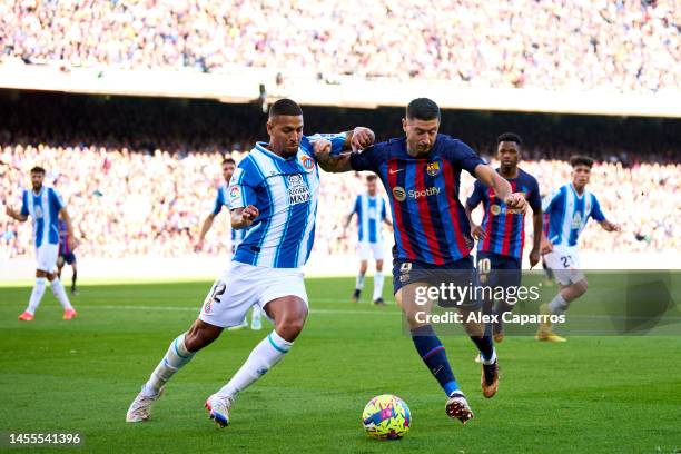 Robert Lewandowski of FC Barcelona battles for the ball with Vinicius 'Vini' De Souza of RCD Espanyol during the LaLiga Santander match between FC...