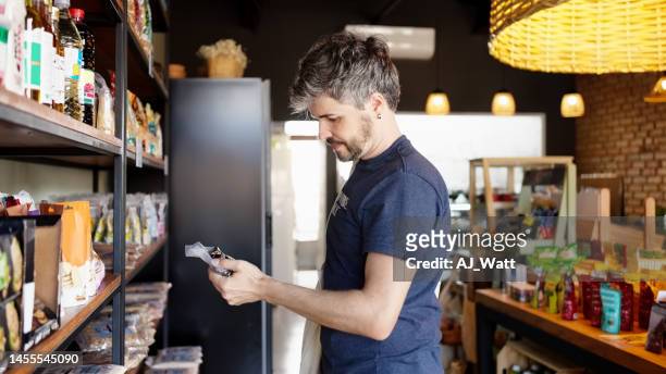 male customer looking at products at a city cafe - nutrition label stock pictures, royalty-free photos & images