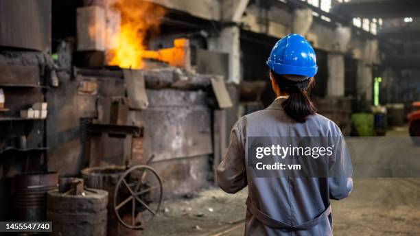 ingeniera japonesa de pie en el taller de la fábrica y verificando el proceso de producción - siderurgicas fotografías e imágenes de stock