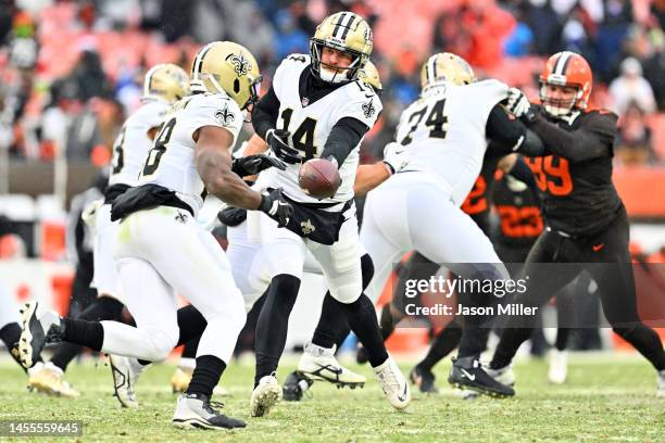 Quarterback Andy Dalton hands off to running back David Johnson of the New Orleans Saints during the second half against the Cleveland Browns at...