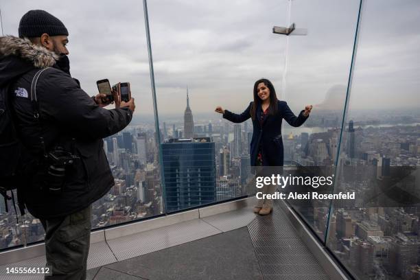 Woman asks a photographer to take a photo at the outdoor deck at The Edge at Hudson Yards on opening day of Sky Skate on January 10, 2023 in New York...