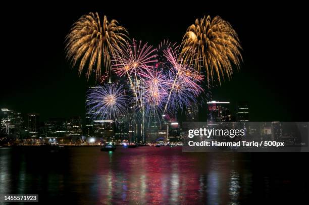 low angle view of firework display over river against sky at night,perth wa,australia - firework display stock-fotos und bilder