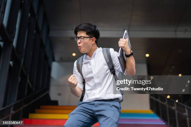 portrait of success asian young businessman arm raised - fun certificate stock pictures, royalty-free photos & images