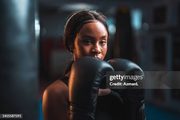 retrato de una joven boxeadora afroamericana seria - guante de boxeo fotografías e imágenes de stock