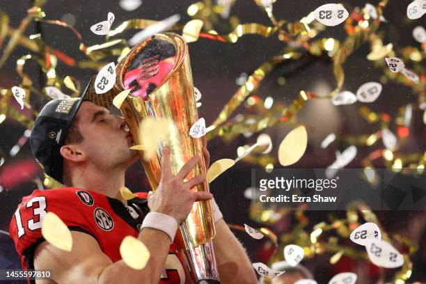 Stetson Bennett of the Georgia Bulldogs celebrates by kissing the College Football Playoff National Championship Trophy after defeating the TCU...