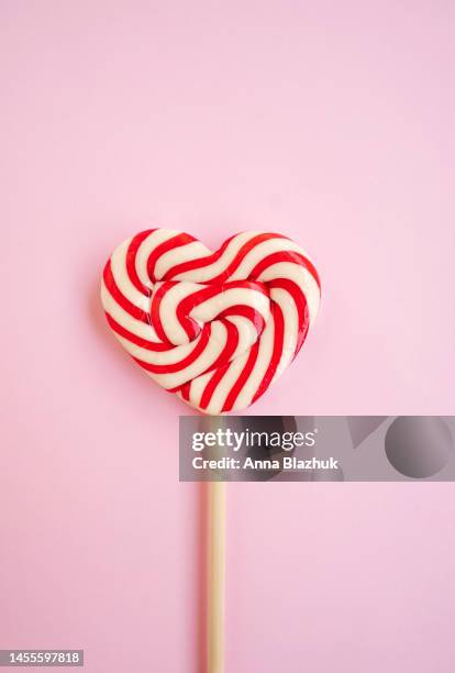 red and white heart shaped lollipop over pink background, greeting card for valentine's day - lollipop stock pictures, royalty-free photos & images