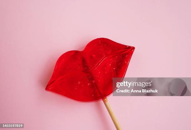 red lips shaped lollipop over pink background, greeting card for valentine's day - candy lips stock pictures, royalty-free photos & images