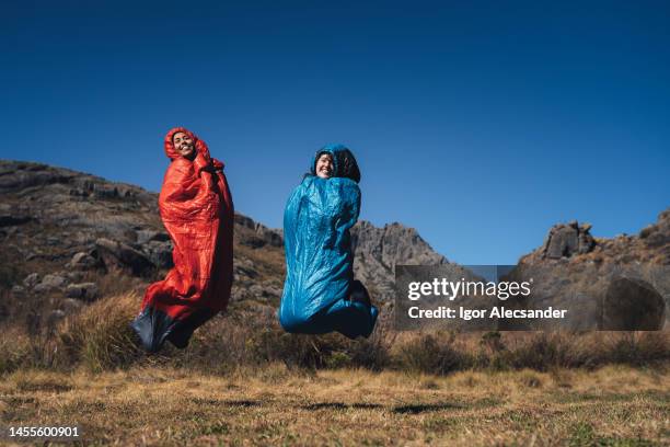 women jumping on sleeping bag - sleeping bag stock pictures, royalty-free photos & images