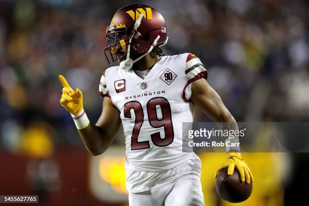 Cornerback Kendall Fuller of the Washington Commanders celebrates while returning an interception for a touchdown against the Dallas Cowboys at...