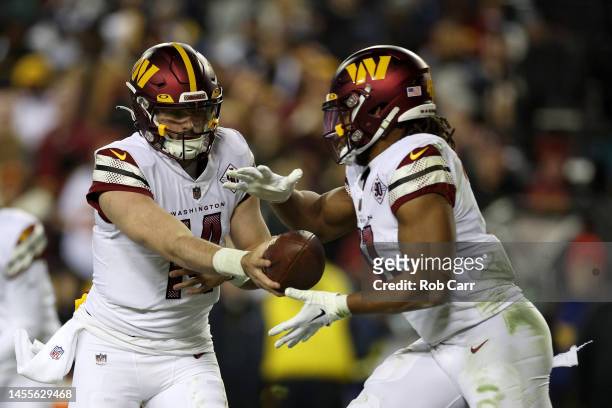 Quarterback Sam Howell hands the ball off to running back Jonathan Williams of the Washington Commanders against the Dallas Cowboys at FedExField on...