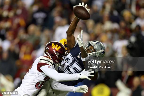 Cornerback Kendall Fuller and safety Jeremy Reaves of the Washington Commanders break up a pass intended for wide receiver Noah Brown of the Dallas...