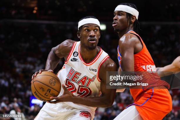 Jimmy Butler of the Miami Heat drives against Shai Gilgeous-Alexander of the Oklahoma City Thunder during the fourth quarter of the game at FTX Arena...