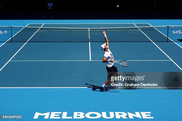 Novak Djokovic of Serbia serves against Daniil Medvedev of Russia in a practice match ahead of the 2023 Australian Open at Melbourne Park on January...