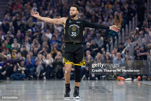 Stephen Curry of the Golden State Warriors celebrates after Draymond Green made a three-point shot against the Phoenix Suns during the second quarter...