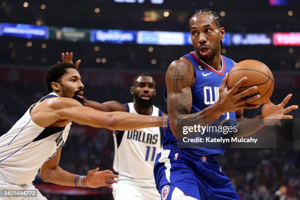 Kawhi Leonard of the Los Angeles Clippers handles the ball against Spencer Dinwiddie and Tim Hardaway Jr. #11 of the Dallas Mavericks during the...