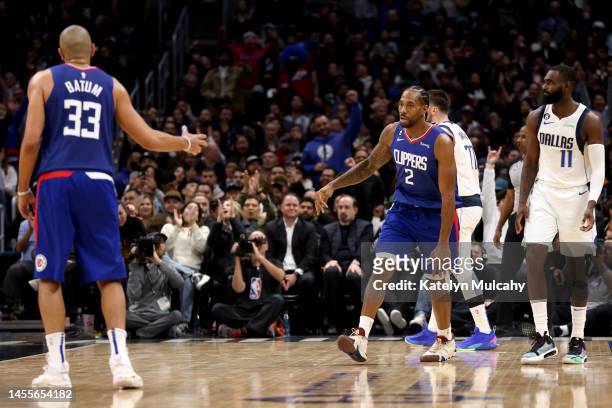 Kawhi Leonard of the Los Angeles Clippers celebrates a three point basket with teammate Nicolas Batum of during the fourth quarter against the Dallas...