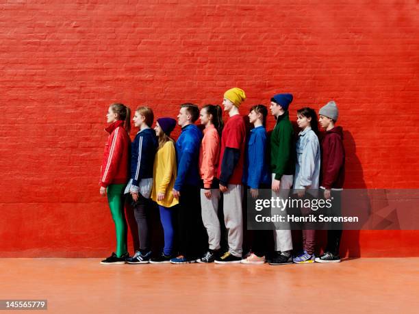 young people standing against each other - schlange stock-fotos und bilder