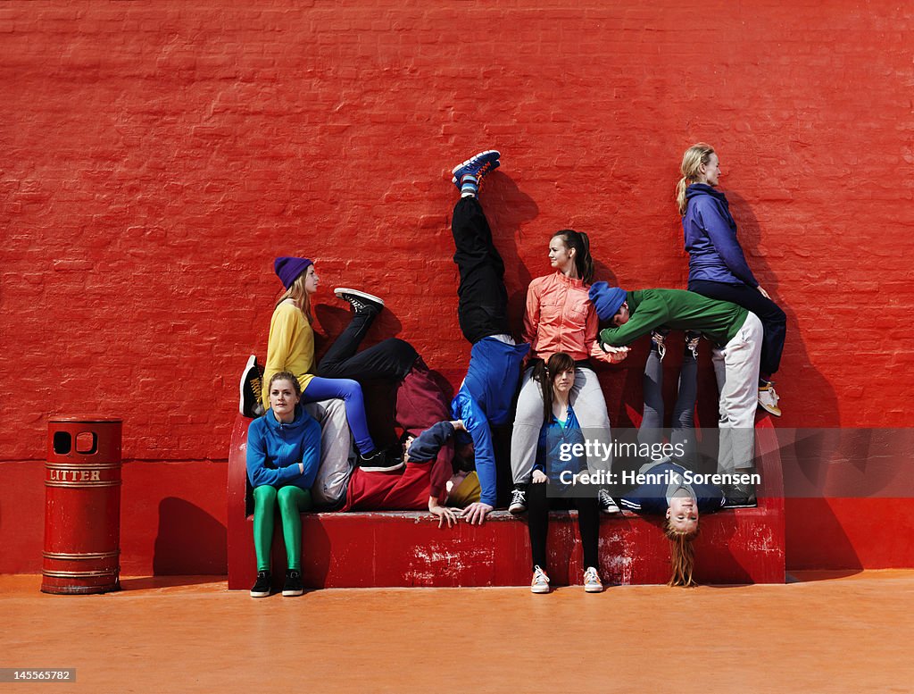 Young people sitting and stading on a bench