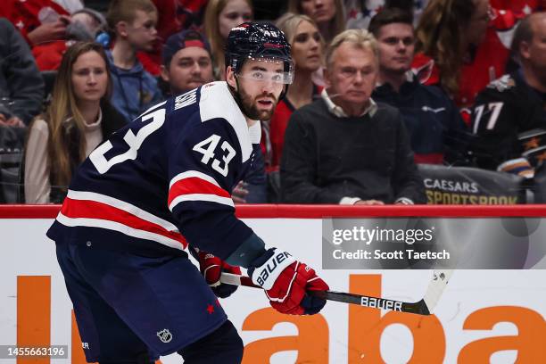 Tom Wilson of the Washington Capitals in action as television personality Pat Sajak watches play during the first period of the game against the...