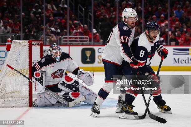 Marcus Bjork of the Columbus Blue Jackets and Alex Ovechkin of the Washington Capitals fight for position in front of Elvis Merzlikins of the...