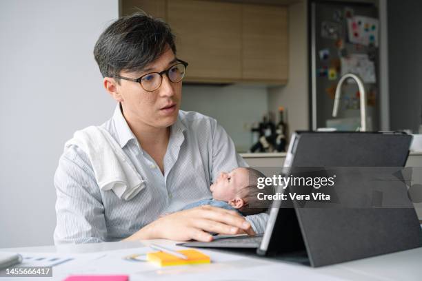 portrait of japanese young father working with technology and nursing baby - vaterschaft stock-fotos und bilder