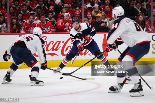 Tom Wilson of the Washington Capitals passes the puck as Tim Berni and Erik Gudbranson of the Columbus Blue Jackets defend during the second period...