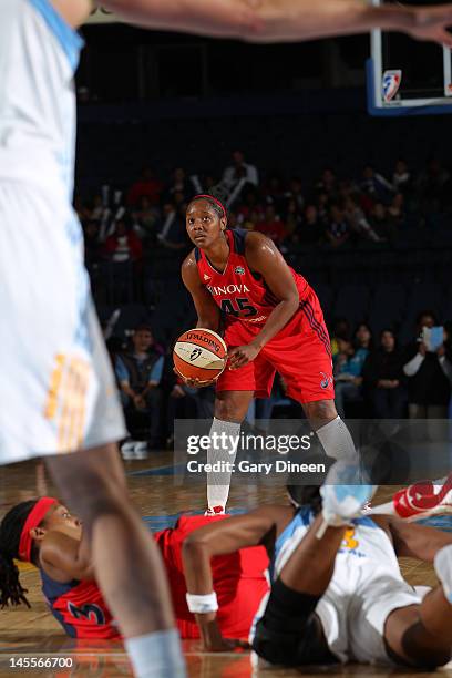 Noelle Quinn of the Washington Mystics looks to pass the ball after teammate Dominique Canty got tangled up with Swin Cash of the Chicago Sky on June...