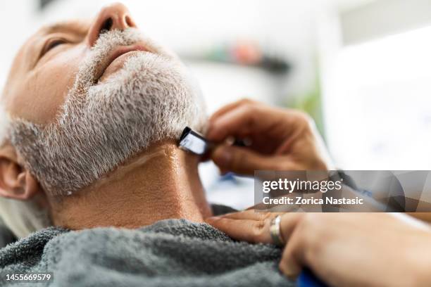 senior man styling his beard - beard trimming stock pictures, royalty-free photos & images