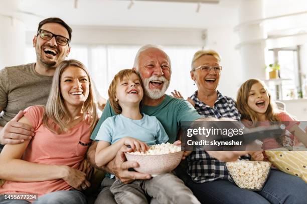 fröhliche großfamilie spaßig beim anschauen eines films zu hause. - familie fernsehen stock-fotos und bilder