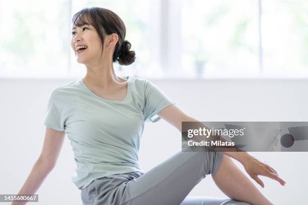 woman stretching in the living room - 女性　日本人　笑顔　30代 ストックフォトと画像