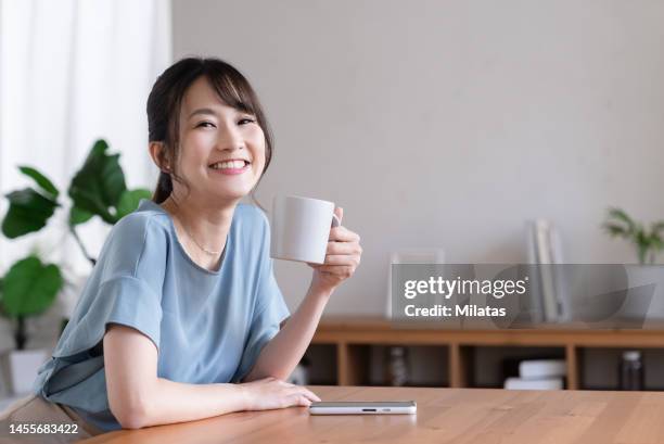 portrait of a woman with a mug - 女性　日本人　笑顔　30代 ストックフォトと画像