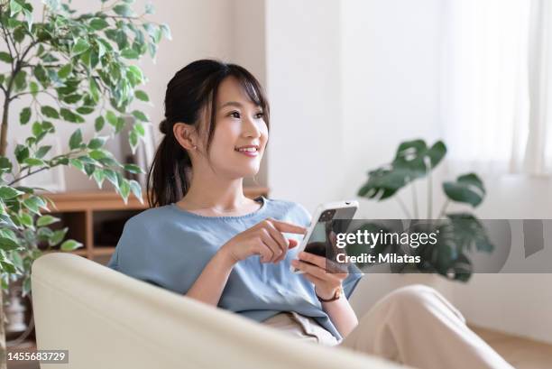 woman relaxing on the sofa - 女性　日本人　笑顔　30代 ストックフォトと画像