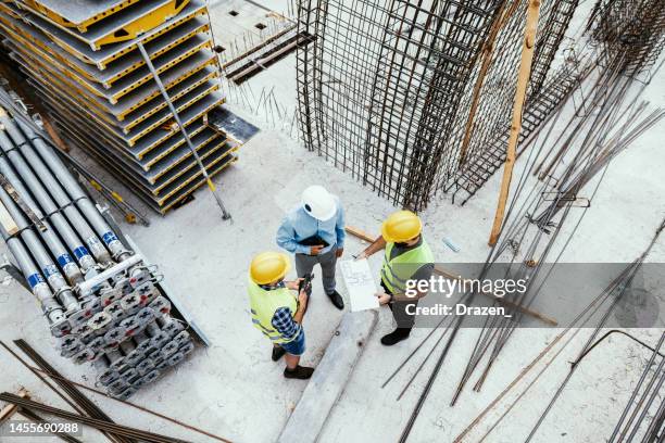 unrecognisable engineers on construction site, high angle view of employees in construction industry - strong foundations stock pictures, royalty-free photos & images