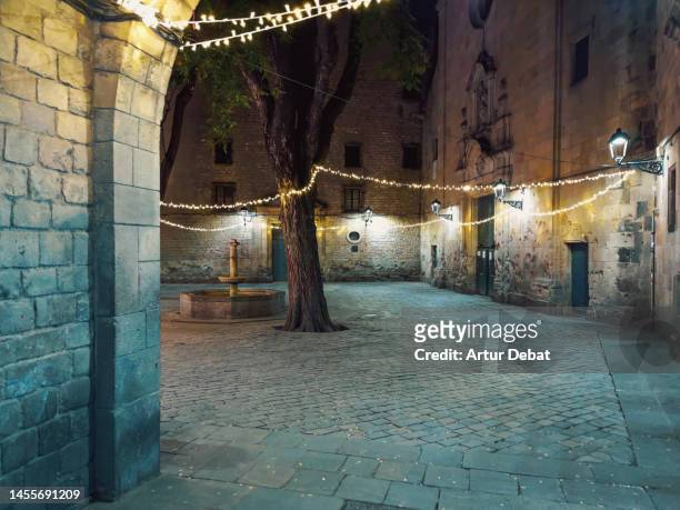 majestic view of the gothic quarter in the barcelona city illuminated at night. sant felip neri square in ciutat vella. - noel sapin stock-fotos und bilder