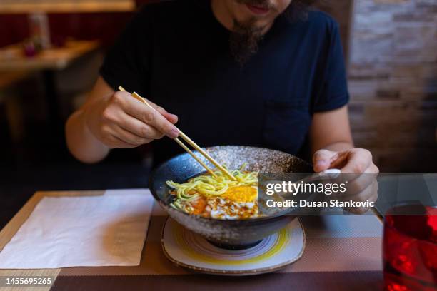 caucasian man eating japanese noodle soup - noodles eating stock pictures, royalty-free photos & images