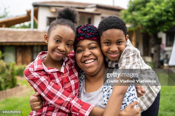 a family hug in the back yard - jamaicaanse etniciteit stockfoto's en -beelden