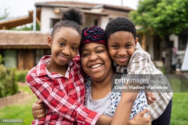 a family hug in the back yard - jamaican culture stock pictures, royalty-free photos & images