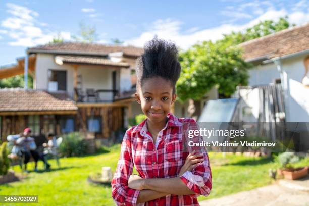 a cute teenage afro girl standing in the middle of her garden - jamaican girl stock pictures, royalty-free photos & images