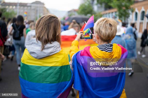 ein lgbtqi-paar beim selfie während der pride-veranstaltung - gender fluid stock-fotos und bilder