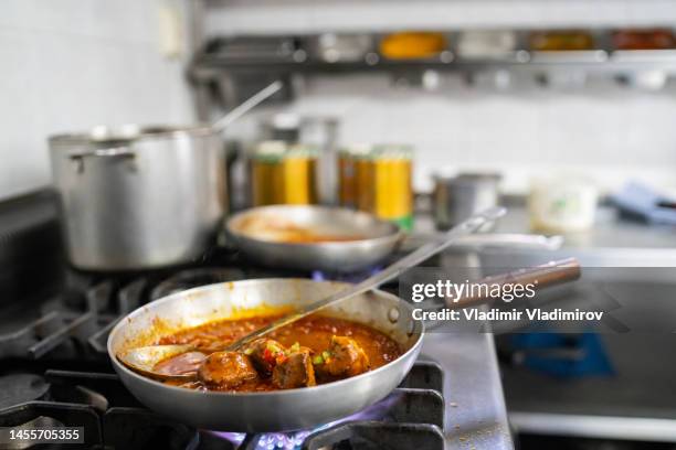 close up of a frying pan and ladle cooking on a stove - chicken tandoori stock pictures, royalty-free photos & images