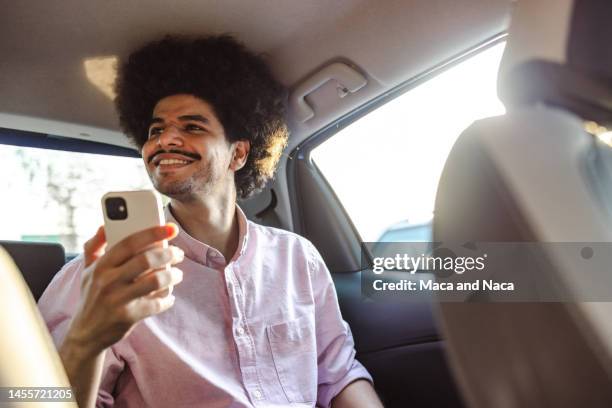 joven montado en un taxi - economía colaborativa fotografías e imágenes de stock