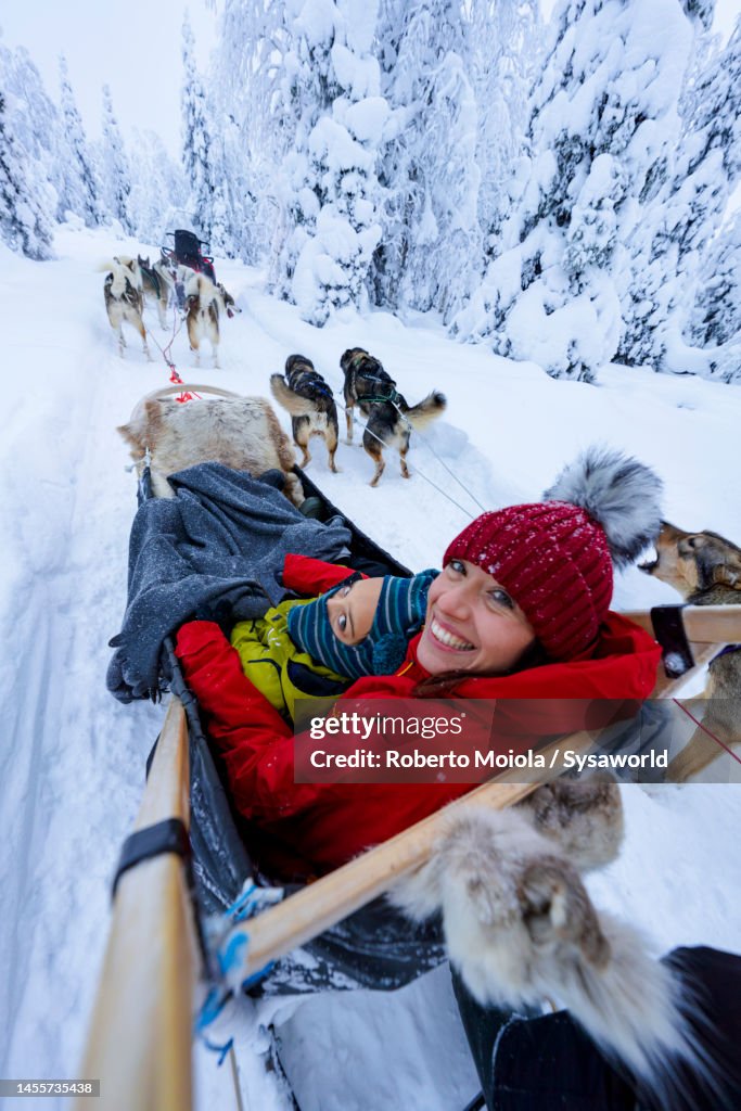 Happy woman with son enjoying dog sledding